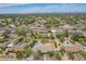 Real estate aerial showcasing a home with a backyard pool, lawn, and nearby residential area at 6102 E Aster Dr, Scottsdale, AZ 85254