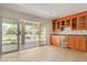 Entertaining area featuring custom cabinets, granite counters, wine fridge, tile floor, and outdoor patio access at 6102 E Aster Dr, Scottsdale, AZ 85254