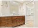 Bathroom featuring double sinks, wood cabinets, a large mirror, and access to a walk-in closet at 6102 E Aster Dr, Scottsdale, AZ 85254