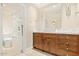 Bright bathroom featuring a wood vanity, marble countertop, and separate tub and shower with marble walls at 6102 E Aster Dr, Scottsdale, AZ 85254