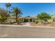 Charming single-story home with lush desert landscaping, mature trees, and inviting walkway at 6102 E Aster Dr, Scottsdale, AZ 85254