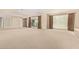Expansive living room featuring neutral carpet, large windows, and light neutral paint at 6102 E Aster Dr, Scottsdale, AZ 85254