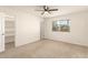 Bedroom with neutral carpet, ceiling fan, window with blinds and walk-in closet with shelving at 6820 E Pinchot Ave, Scottsdale, AZ 85251