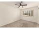 Bedroom with neutral carpet, ceiling fan, and shuttered window at 6820 E Pinchot Ave, Scottsdale, AZ 85251