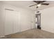 Bedroom with neutral carpet, ceiling fan, closet and door at 6820 E Pinchot Ave, Scottsdale, AZ 85251