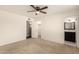 Bedroom with neutral carpet, ceiling fan, ensuite bathroom and walk-in closet with shelving at 6820 E Pinchot Ave, Scottsdale, AZ 85251