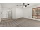 Bright bedroom features neutral carpet, ceiling fan, and a window with wood-look blinds at 7139 W Mcrae Way, Glendale, AZ 85308