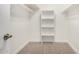 Walk-in closet has carpet flooring, shelving and hanging storage for organization at 7139 W Mcrae Way, Glendale, AZ 85308