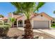 Charming single-story home with well-maintained landscaping, desert rock, mature palm trees, and a tile roof at 7139 W Mcrae Way, Glendale, AZ 85308