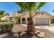 Charming single-story home with well-maintained landscaping, desert rock, mature palm trees, and a tile roof at 7139 W Mcrae Way, Glendale, AZ 85308