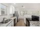 Kitchen featuring granite countertops, stainless appliances, and subway tile at 7139 W Mcrae Way, Glendale, AZ 85308