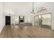 Bright and open living room with wood-look floors, new carpet, large windows and doors, and modern lighting at 7139 W Mcrae Way, Glendale, AZ 85308