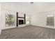 Spacious living room featuring a fireplace, new carpet, large windows, and neutral paint at 7139 W Mcrae Way, Glendale, AZ 85308