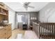 Bedroom featuring a crib, light-colored wood floors, shelving, and neutral wall tones with floral decor at 7610 N Via De Manana Dr, Scottsdale, AZ 85258