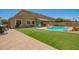 Expansive backyard featuring a pool, artificial turf, and outdoor seating area, perfect for entertaining guests at 7858 W Fetlock Trl, Peoria, AZ 85383