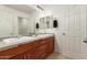Bathroom with double sinks, modern fixtures, wood cabinets, and neutral wall tones at 7858 W Fetlock Trl, Peoria, AZ 85383