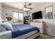 Comfortable bedroom with a large window, ceiling fan, and dresser with mounted TV at 7858 W Fetlock Trl, Peoria, AZ 85383