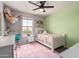 Bright bedroom features plush rug, ceiling fan and decorative accents with a view out the window at 7858 W Fetlock Trl, Peoria, AZ 85383