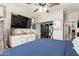 Well-appointed bedroom includes a dresser with TV, ceiling fan, and closet with laundry at 7858 W Fetlock Trl, Peoria, AZ 85383