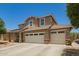 Tan two-story home with a three-car garage, desert landscaping, and neutral-colored trim accents at 7858 W Fetlock Trl, Peoria, AZ 85383
