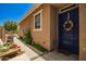 Charming home exterior featuring a blue front door, plants, and a landscaped walkway at 7858 W Fetlock Trl, Peoria, AZ 85383