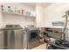 Laundry room with stainless steel washer and dryer and upper and lower storage shelving at 7858 W Fetlock Trl, Peoria, AZ 85383