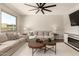 Inviting living room offering ample natural light, a cozy seating area, and a modern fireplace at 7858 W Fetlock Trl, Peoria, AZ 85383