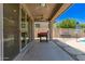 Covered patio area complete with a grill, ample space for outdoor seating, and access to the backyard at 7858 W Fetlock Trl, Peoria, AZ 85383