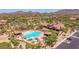 Aerial view of a community clubhouse with a resort-style pool, spa, and well-manicured landscaping and parking at 8304 E Inca St, Mesa, AZ 85207