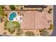 Aerial shot of a home highlighting the backyard with a pool, putting green, patio, and desert surroundings at 8304 E Inca St, Mesa, AZ 85207