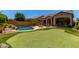 Lush backyard with a putting green, swimming pool, fire pit, and covered patio, perfect for outdoor entertaining and relaxation at 8304 E Inca St, Mesa, AZ 85207
