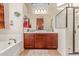 Bathroom with double vanity, dark wood cabinets, tub, and glass enclosed shower at 8304 E Inca St, Mesa, AZ 85207