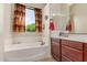 Bathroom with garden tub, privacy window, and vanity with dark wood cabinets at 8304 E Inca St, Mesa, AZ 85207