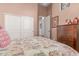Bedroom with patterned bedspread, double door closet, carpeted floor, and ensuite bathroom at 8304 E Inca St, Mesa, AZ 85207