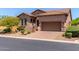 Charming home with a stone facade, well-maintained landscaping, and a spacious driveway leading to a two-car garage at 8304 E Inca St, Mesa, AZ 85207