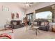 Inviting living room with comfortable leather sofas, a ceiling fan, and a large window offering scenic views and natural light at 8304 E Inca St, Mesa, AZ 85207