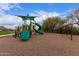 Community playground with slides, swings, and play structures set in a sandy area with green trees at 8304 E Inca St, Mesa, AZ 85207