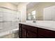 Bathroom features light stone floors, dark cabinets and a shower, with white tiles and white walls at 9249 E Sector Dr, Mesa, AZ 85212