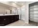 Modern bathroom featuring a double vanity, glass enclosed shower, and a separate storage closet at 9249 E Sector Dr, Mesa, AZ 85212