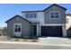 Charming two-story home featuring a dark garage door, complemented by a well-maintained front yard and clear blue sky at 9249 E Sector Dr, Mesa, AZ 85212