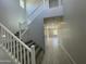Bright foyer with staircase, neutral walls, and wood-look tile flooring leading into a spacious area with natural light at 9249 E Sector Dr, Mesa, AZ 85212