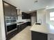 Modern kitchen with dark cabinets, stainless steel appliances, stylish backsplash and a center island, perfect for cooking at 9249 E Sector Dr, Mesa, AZ 85212