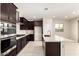 Gourmet kitchen boasts dark cabinets, stainless steel appliances, and a large center island at 9249 E Sector Dr, Mesa, AZ 85212