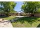 Spacious backyard with lush green grass, a basketball court, and desert landscaping at 9372 W Louise Dr, Peoria, AZ 85383