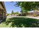 A large backyard with green grass, a pool, a basketball court, and a covered patio with furniture at 9372 W Louise Dr, Peoria, AZ 85383