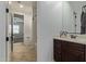 A look into the bathroom with vanity and decorative framed mirror and tile floors at 9372 W Louise Dr, Peoria, AZ 85383