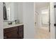 Bathroom boasts dark wood vanity with cream countertop and decorative framed mirror at 9372 W Louise Dr, Peoria, AZ 85383
