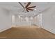 Spacious bedroom with neutral walls, carpeted floor, and a ceiling fan and an opening to the second floor at 9372 W Louise Dr, Peoria, AZ 85383