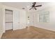 This bright bedroom features neutral walls, carpet flooring, a closet with sliding doors, and a ceiling fan at 9372 W Louise Dr, Peoria, AZ 85383