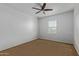 This room features neutral walls, carpet flooring, a ceiling fan, and a window for natural lighting at 9372 W Louise Dr, Peoria, AZ 85383
